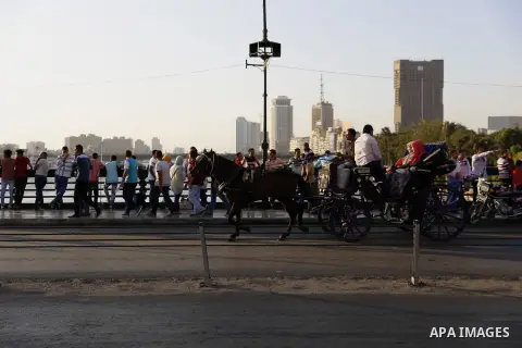 Egyptians walk past Nile River on the third day of Eid al-Fitr holiday which marks the end of the Muslim holy month of Ramadan, in Cairo, Egypt, on July 08, 2016. Photo by Amr Sayed