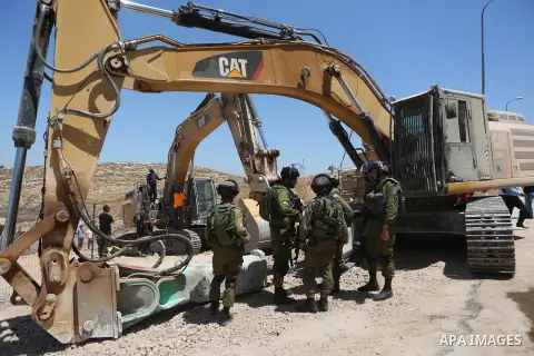 Palestinians try to prevent Israeli excavator from clearing their land during a protest against Jewish settlements, near the village of Deir Qaddis near the West Bank city of Ramallah July 13, 2016. Photo by Shadi Hatem