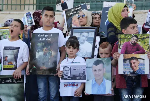 Relatives of Palestinian prisoners in Israeli jails take part in a protest against the decision of Israeli authorities minimize visits the Palestinian prisoners in front of Red cross office, in Jerusalem, on July 13, 201...
