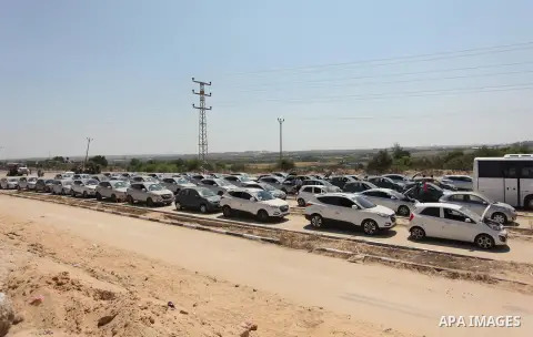 A Palestinian man inspects vehicles that came from Israel to serve the Gaza Strip market on July 14, 2016 in the Palestinian side of the Erez crossing with Israel. Israel opened the major Erez crossing point between Isra...