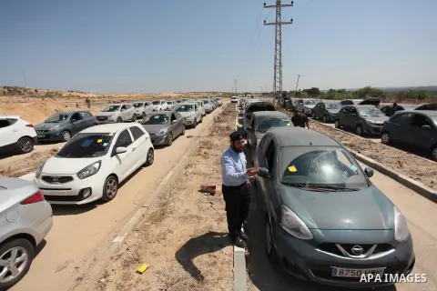 A Palestinian man inspects vehicles that came from Israel to serve the Gaza Strip market on July 14, 2016 in the Palestinian side of the Erez crossing with Israel. Israel opened the major Erez crossing point between Isra...