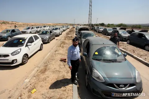 A Palestinian man inspects vehicles that came from Israel to serve the Gaza Strip market on July 14, 2016 in the Palestinian side of the Erez crossing with Israel. Israel opened the major Erez crossing point between Isra...