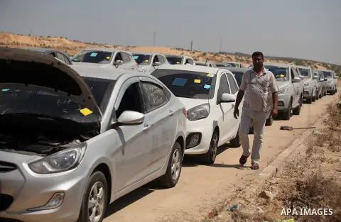A Palestinian man inspects vehicles that came from Israel to serve the Gaza Strip market on July 14, 2016 in the Palestinian side of the Erez crossing with Israel. Israel opened the major Erez crossing point between Isra...