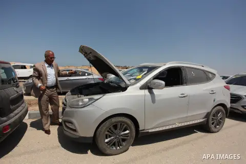 A Palestinian man inspects vehicles that came from Israel to serve the Gaza Strip market on July 14, 2016 in the Palestinian side of the Erez crossing with Israel. Israel opened the major Erez crossing point between Isra...