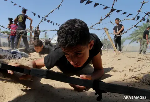 Young Palestinians take part in a military-style exercise at a summer camp organised by the Islamic Jihad movement in Khan Yunis in the southern Gaza Strip, during the youngsters' summer school vacation, on July 14, 2016...