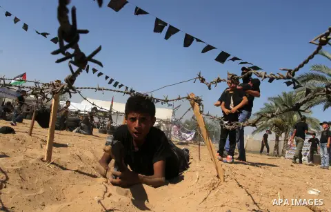 Young Palestinians take part in a military-style exercise at a summer camp organised by the Islamic Jihad movement in Khan Yunis in the southern Gaza Strip, during the youngsters' summer school vacation, on July 14, 2016...