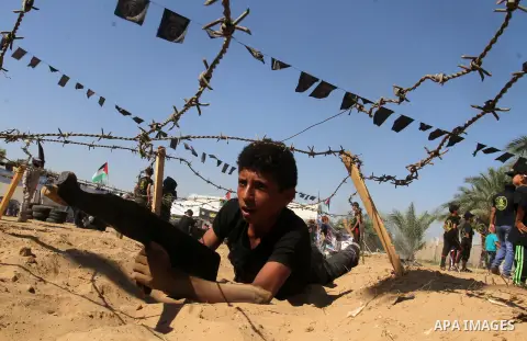 Young Palestinians take part in a military-style exercise at a summer camp organised by the Islamic Jihad movement in Khan Yunis in the southern Gaza Strip, during the youngsters' summer school vacation, on July 14, 2016...