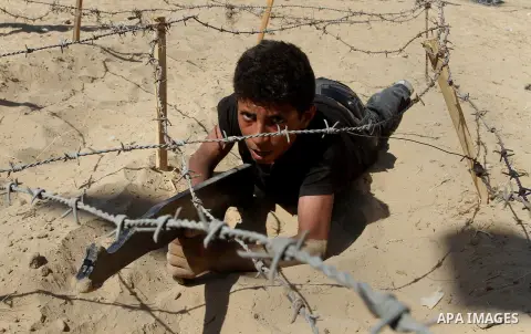 Young Palestinians take part in a military-style exercise at a summer camp organised by the Islamic Jihad movement in Khan Yunis in the southern Gaza Strip, during the youngsters' summer school vacation, on July 14, 2016...