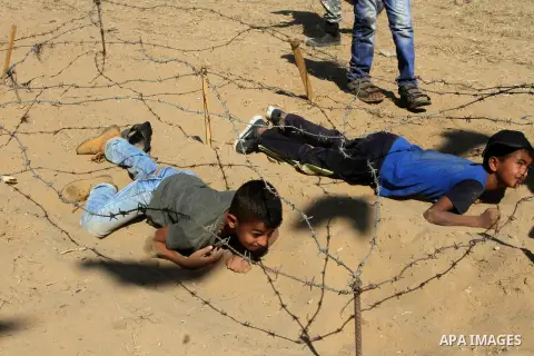Young Palestinians take part in a military-style exercise at a summer camp organised by the Islamic Jihad movement in Khan Yunis in the southern Gaza Strip, during the youngsters' summer school vacation, on July 14, 2016...