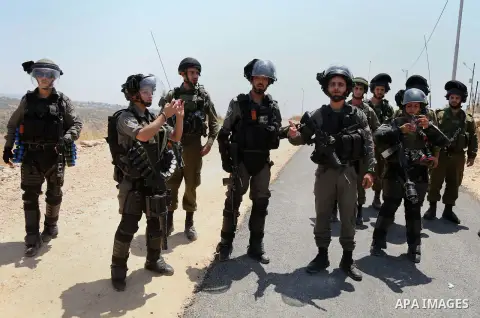 Israeli security forces take position during clashes with Palestinian protesters following a demonstration against Israel's controversial separation barrier and Jewish settlements, in the West Bank village of Bilin, near...