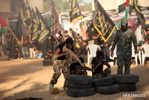 Palestinian youths take part in a military-style graduation ceremony at a summer camp organized by the Islamic Jihad Movement in Khan Younis in the southern Gaza Strip July 15, 2016. Photo by Ashraf Amra