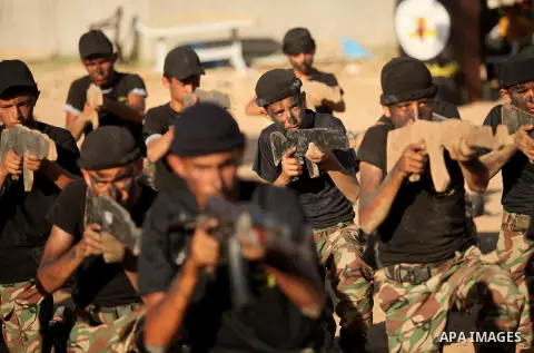 Palestinian youths take part in a military-style graduation ceremony at a summer camp organized by the Islamic Jihad Movement in Khan Younis in the southern Gaza Strip July 15, 2016. Photo by Ashraf Amra