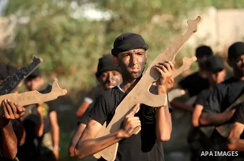 Palestinian youths take part in a military-style graduation ceremony at a summer camp organized by the Islamic Jihad Movement in Khan Younis in the southern Gaza Strip July 15, 2016. Photo by Ashraf Amra