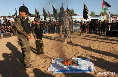Palestinian youths take part in a military-style graduation ceremony at a summer camp organized by the Islamic Jihad Movement in Khan Younis in the southern Gaza Strip July 15, 2016. Photo by Ashraf Amra