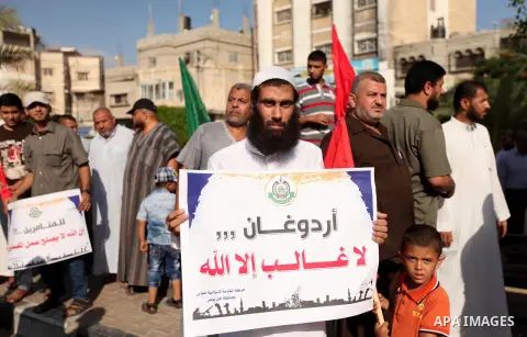 Palestinians hold banners during a protest against military coup attempt in Turkey, in Khan Younis in the southern Gaza strip, on July 16, 2016. President Recep Tayyip Erdogan battled to regain control over Turkey on Jul...