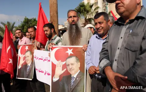 Palestinians hold banners during a protest against military coup attempt in Turkey, in Khan Younis in the southern Gaza strip, on July 16, 2016. Photo by Ashraf Amra
