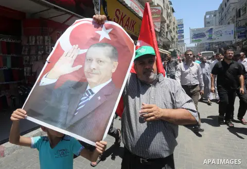 Palestinian supporters of the Hamas movement wave their national flag and Turkey's flag as they shout slogans against the military coup attempt in Turkey, during a demonstration in Gaza City, on July 16, 2016. Erdogan ba...