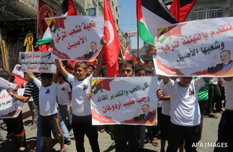 Palestinian supporters of the Hamas movement wave their national flag and Turkey's flag as they shout slogans against the military coup attempt in Turkey, during a demonstration in Gaza City, on July 16, 2016. Erdogan ba...