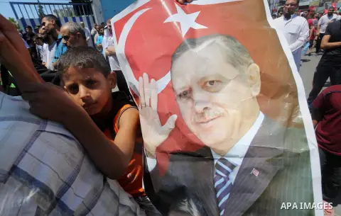 Palestinian supporters of the Hamas movement wave their national flag and Turkey's flag as they shout slogans against the military coup attempt in Turkey, during a demonstration in Gaza City, on July 16, 2016. Erdogan ba...