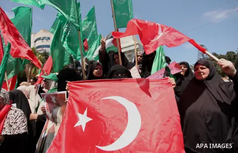 Palestinian supporters of the Hamas movement hold portraits of Turkish President Recep Tayyip Erdogan as they shout slogans against the military coup attempt in Turkey, during a demonstration in Gaza City, on July 17, 20...