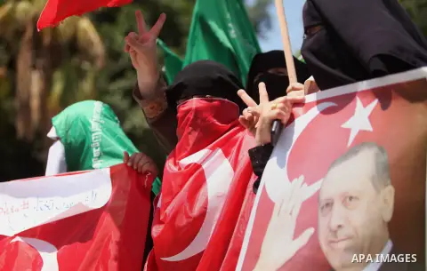 Palestinian supporters of the Hamas movement hold portraits of Turkish President Recep Tayyip Erdogan as they shout slogans against the military coup attempt in Turkey, during a demonstration in Gaza City, on July 17, 20...