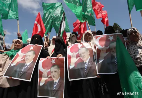Palestinian supporters of the Hamas movement hold portraits of Turkish President Recep Tayyip Erdogan as they shout slogans against the military coup attempt in Turkey, during a demonstration in Gaza City, on July 17, 20...