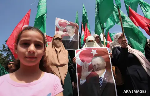 Palestinian supporters of the Hamas movement hold portraits of Turkish President Recep Tayyip Erdogan as they shout slogans against the military coup attempt in Turkey, during a demonstration in Gaza City, on July 17, 20...
