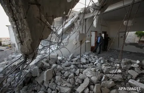 Palestinian men check on July 18, 2016 the rubble of a house belonging to a Palestinian man accused by Israeli authorities in taking part in an attack in Jerusalem in which an Israeli policewoman was killed, after it was...