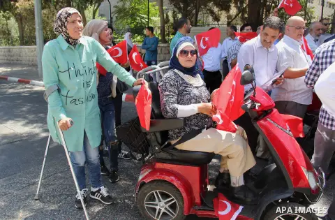 Palestinians wave Turkish flags during a protest against the military coup attempt in Turkey, in front of the Turkish consulate in east Jerusalem on July 18, 2016. Photo by Mahfouz Abu Turk