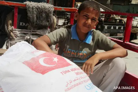 Palestinians receive Turkish aid at an aid distribution centre of the United Nations Relief and Works Agency (UNRWA) in the southern Gaza Strip town of Rafah, on July 18, 2016. Photo by Abed Rahim Khatib