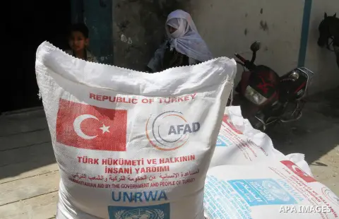 Palestinians receive Turkish aid at an aid distribution centre of the United Nations Relief and Works Agency (UNRWA) in the southern Gaza Strip town of Rafah, on July 18, 2016. Photo by Abed Rahim Khatib