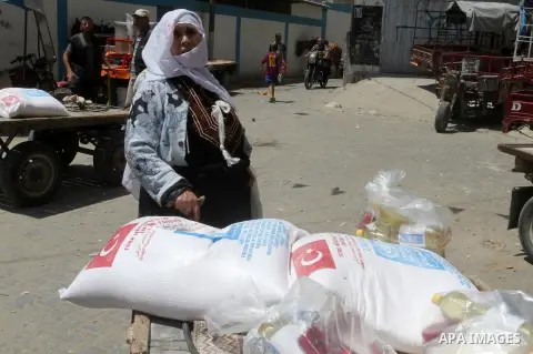 Palestinians receive Turkish aid at an aid distribution centre of the United Nations Relief and Works Agency (UNRWA) in the southern Gaza Strip town of Rafah, on July 18, 2016. Photo by Abed Rahim Khatib