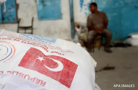 Palestinians receive Turkish aid at an aid distribution centre of the United Nations Relief and Works Agency (UNRWA) in the southern Gaza Strip town of Rafah, on July 18, 2016. Photo by Abed Rahim Khatib