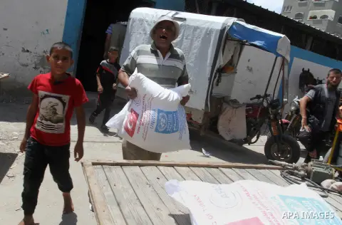 Palestinians receive Turkish aid at an aid distribution centre of the United Nations Relief and Works Agency (UNRWA) in the southern Gaza Strip town of Rafah, on July 18, 2016. Photo by Abed Rahim Khatib
