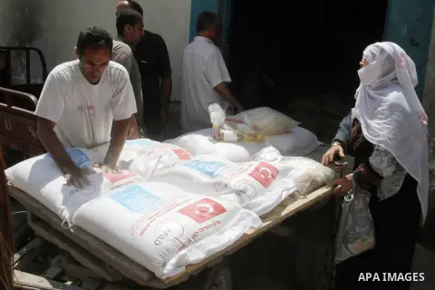 Palestinians receive Turkish aid at an aid distribution centre of the United Nations Relief and Works Agency (UNRWA) in the southern Gaza Strip town of Rafah, on July 18, 2016. Photo by Abed Rahim Khatib