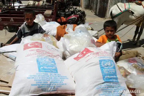 Palestinians receive Turkish aid at an aid distribution centre of the United Nations Relief and Works Agency (UNRWA) in the southern Gaza Strip town of Rafah, on July 18, 2016. Photo by Abed Rahim Khatib