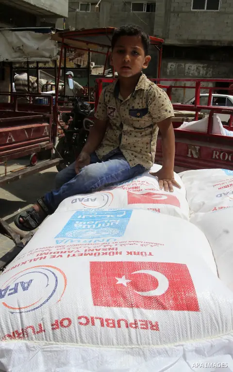 Palestinians receive Turkish aid at an aid distribution centre of the United Nations Relief and Works Agency (UNRWA) in the southern Gaza Strip town of Rafah, on July 18, 2016. Photo by Abed Rahim Khatib