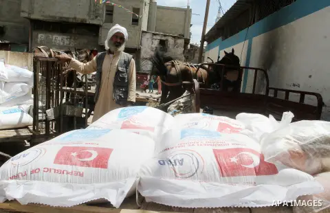 Palestinians receive Turkish aid at an aid distribution centre of the United Nations Relief and Works Agency (UNRWA) in the southern Gaza Strip town of Rafah, on July 18, 2016. Photo by Abed Rahim Khatib