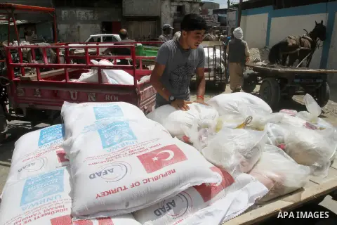Palestinians receive Turkish aid at an aid distribution centre of the United Nations Relief and Works Agency (UNRWA) in the southern Gaza Strip town of Rafah, on July 18, 2016. Photo by Abed Rahim Khatib