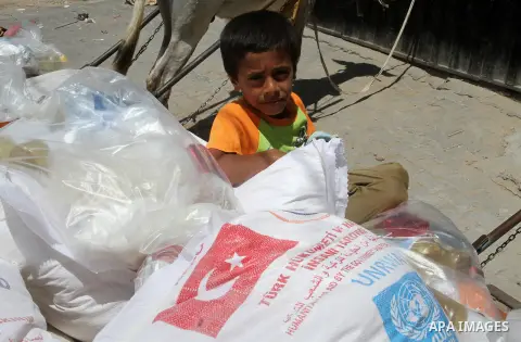 Palestinians receive Turkish aid at an aid distribution centre of the United Nations Relief and Works Agency (UNRWA) in the southern Gaza Strip town of Rafah, on July 18, 2016. Photo by Abed Rahim Khatib