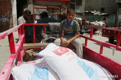 Palestinians receive Turkish aid at an aid distribution centre of the United Nations Relief and Works Agency (UNRWA) in the southern Gaza Strip town of Rafah, on July 18, 2016. Photo by Abed Rahim Khatib