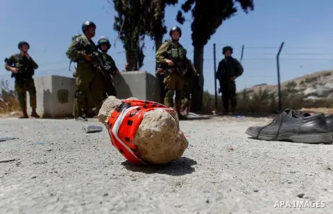 The shoes of a Palestinian assailant are seen on the ground after she stabbed and wounded two Israeli soldiers before being hit by a gunshot next to the entrance of the al-Arub refugee camp near the city of Hebron in the...