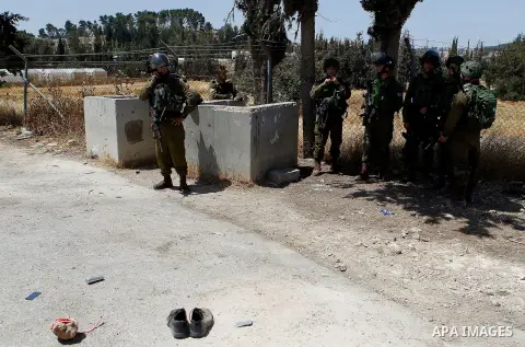 Israeli soldiers are seen at the site of a stabbing attack by a Palestinian man next to the entrance of the al-Arub refugee camp near the city of Hebron in the Israeli-occupied West Bank on July 18, 2016 in which two sol...