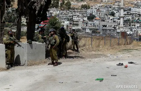 Israeli soldiers are seen at the site of a stabbing attack by a Palestinian man next to the entrance of the al-Arub refugee camp near the city of Hebron in the Israeli-occupied West Bank on July 18, 2016 in which two sol...