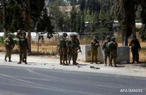 Israeli soldiers are seen at the site of a stabbing attack by a Palestinian man next to the entrance of the al-Arub refugee camp near the city of Hebron in the Israeli-occupied West Bank on July 18, 2016 in which two sol...