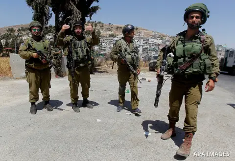 Israeli soldiers are seen at the site of a stabbing attack by a Palestinian man next to the entrance of the al-Arub refugee camp near the city of Hebron in the Israeli-occupied West Bank on July 18, 2016 in which two sol...