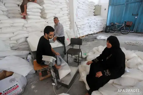 Palestinians receive Turkish aid at an aid distribution centre in Gaza city, on July 19, 2016. The aid, consisting of flour, sugar and rice, was allowed into the Palestinian territory via Israel’s Kerem Shalom crossing a...