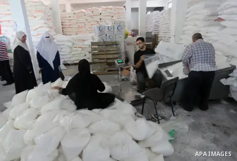 Palestinians receive Turkish aid at an aid distribution centre in Gaza city, on July 19, 2016. The aid, consisting of flour, sugar and rice, was allowed into the Palestinian territory via Israel’s Kerem Shalom crossing a...