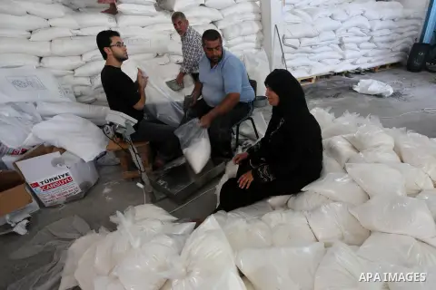 Palestinians receive Turkish aid at an aid distribution centre in Gaza city, on July 19, 2016. The aid, consisting of flour, sugar and rice, was allowed into the Palestinian territory via Israel’s Kerem Shalom crossing a...