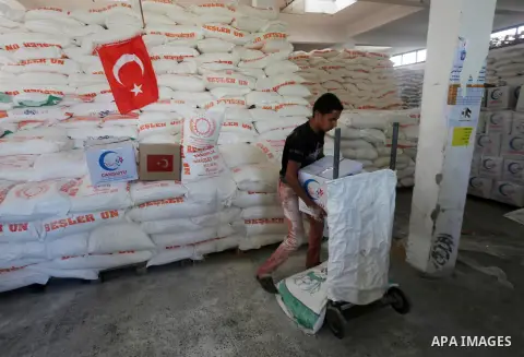 Palestinians receive Turkish aid at an aid distribution centre in Gaza city, on July 19, 2016. The aid, consisting of flour, sugar and rice, was allowed into the Palestinian territory via Israel’s Kerem Shalom crossing a...